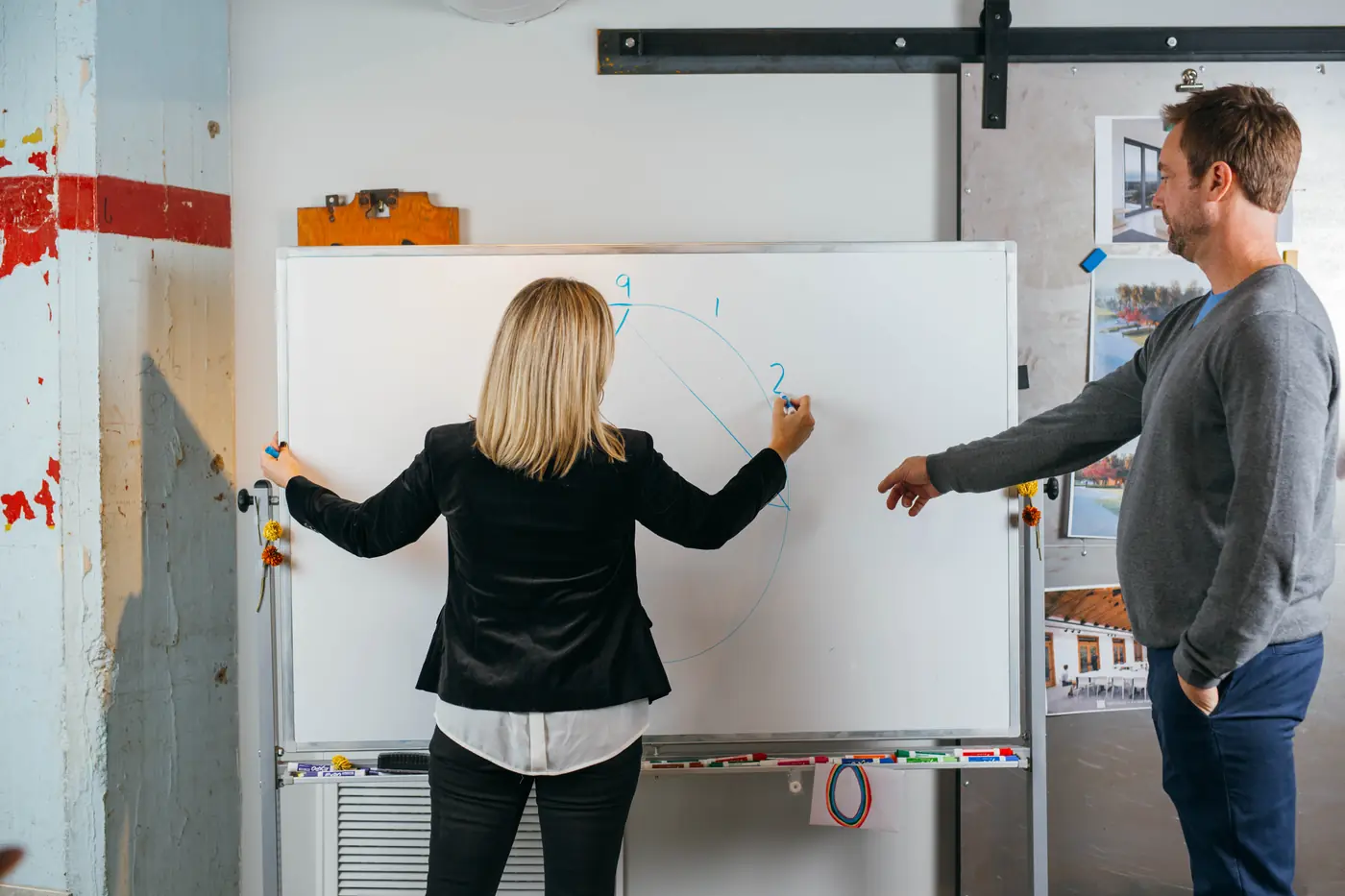 Shelley mapping ideas on a whiteboard with a client